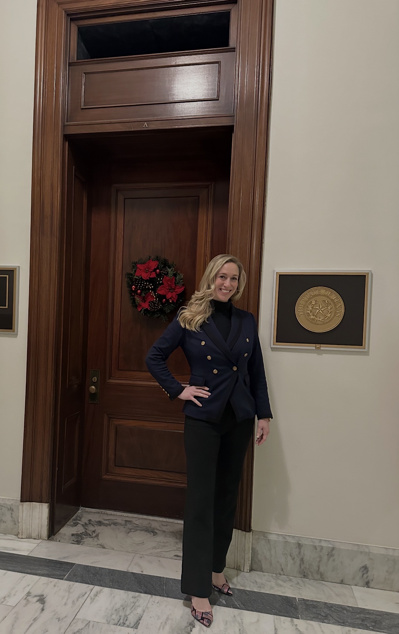 Rachel Fischer — Independent Advocacy Rachel Fischer standing beside a State of Texas seal during a legislative session