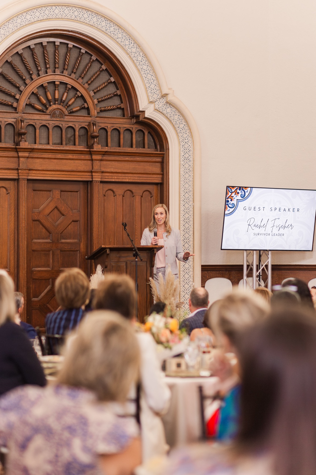 Rachel Fischer — Speaking at Unbound Rachel Fischer speaking at an Unbound event, standing at a podium marked Guest Speaker Rachel Fischer, Survivor Leader